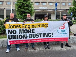 Neljä henkilöä pitelemässä kylttiä, jossa lukee: Jones Engineering: no more union-busting!